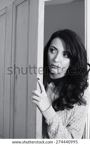 Young woman knocking on door dressed in vintage style