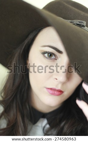 Beautiful woman wearing floppy hat covering one eye