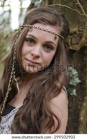 Portrait of a teenage girl looking straight to camera styled in a hippie look.