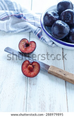 Plums Sliced plums and whole plums on a white rustic background