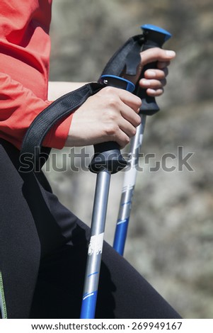 Hiker holding hiking poles with straps, close-up