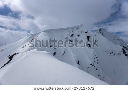 Snow cornice near Mount Cheget summit with snowboard track