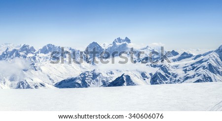 Snowy winter Greater Caucasus mountains (Ushba, Kogutai and other) at sunny day. Panorama view from ski slope Elbrus, Kabardino-Balkaria, Russia