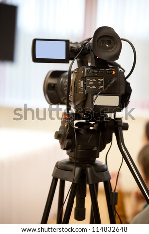 The image of video camera under the tripod