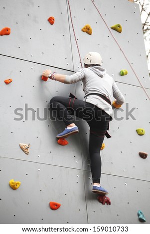 the image of Girl exercises on indoor rock climber