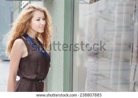 beautiful woman looking at shop window