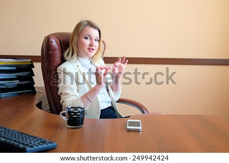 Beautiful secretary doing manicure in the office