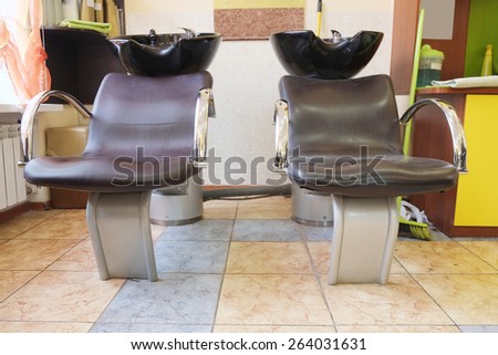 Black bowl for head washing and chairs in hairdresser salon