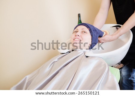 Hair salon. Woman with towel on head.