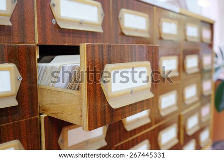 Old wooden card catalog with one opened drawer in library