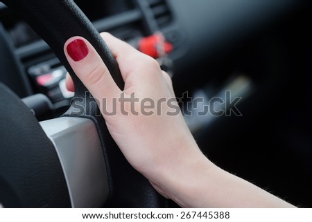 Hand of a woman behind the wheel of car