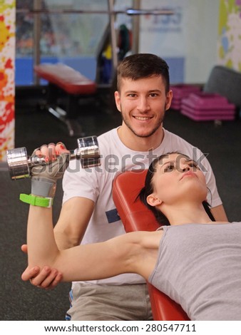 Young fitness coach stands by the girl drill