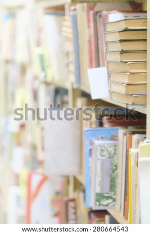 The image of books on the shelf in a library. The books on the background are blurred