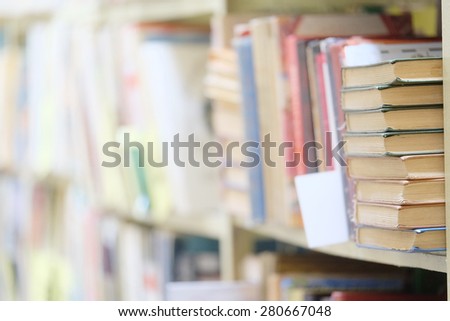 The image of books on the shelf in a library. The books on the background are blurred