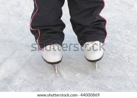 The image of child legs with figure skates on a skating-rink