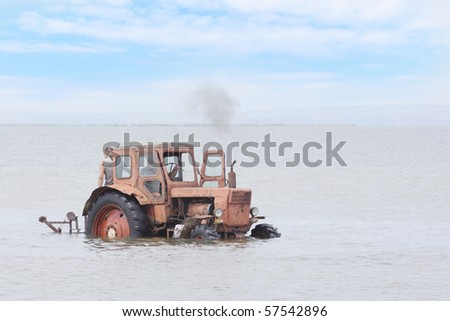 The image of tractor drives under the water