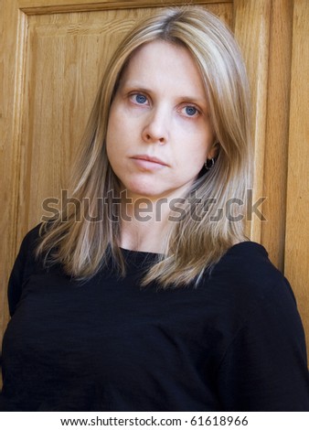 Young blonde woman looking away from the camera, a sad look on her face