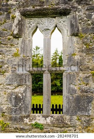 Stone arches, columns and plinths form a medieval window at Aughnanure Castle in Co. Galway. The opening provided a view onto adjoining farm land and features some ancient stone carvings.