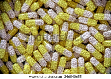 Pharmacy theme, Heap of yellow and white round capsule pills with medicine antibiotic.