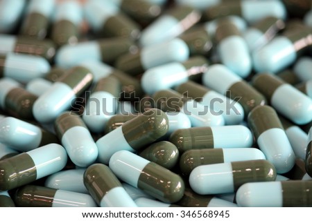 Pharmacy theme, Heap of blue green round capsule pills with medicine antibiotic. Shallow DOF