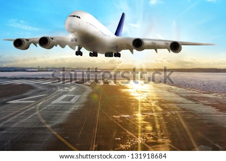 Passenger airplane landing on runway in airport. Evening.