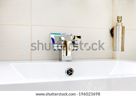 Chromium-plate tap on white sink
