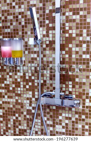 Modern designer tap and shower in bathroom.