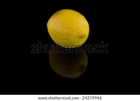 Single Lemon  with light shade on  black background.