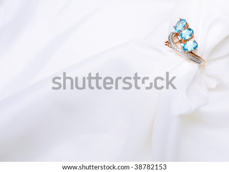 Golden Ring with  sapphire on white silk.