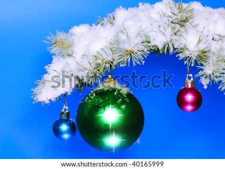 Christmas and New Year decoration- balls with  snow-covered fir branches .On blue background