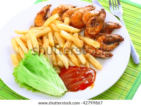 Deep-fried potatoes with fry shrimps and lettuce. Isolated over green mat.
