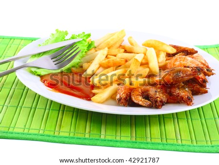 Deep-fried potatoes with fry shrimps and lettuce. Isolated over green mat.