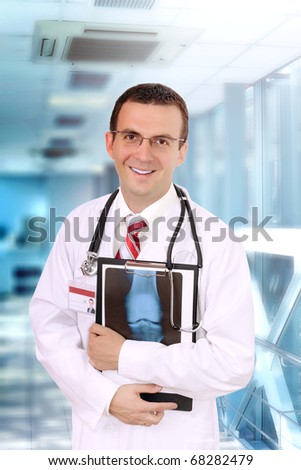 Friendly medical doctor stand in hospital with a x-ray image and medical pad.