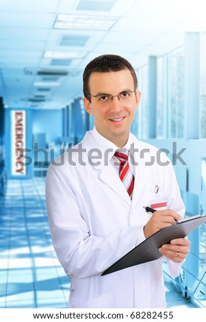Portrait of friendly medical doctor in hospital  with medical pad.