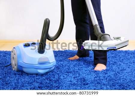 Vacuum cleaner in action  - a men cleaner a carpet.