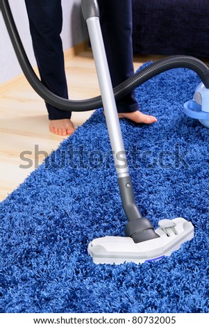 Vacuum cleaner in action  - a men cleaner a carpet.