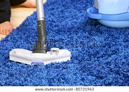 The metal pipe of vacuum cleaner in action -clean a carpet and laminated flooring board.