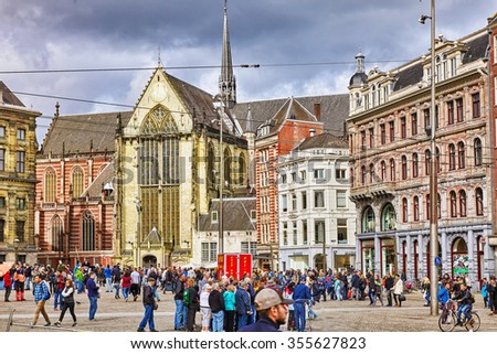AMSTERDAM, NETHERLANDS - SEPTEMBER 15, 2015: Beautiful Amsterdam, people in the centre of  Dam Square in the daytime.Square is a central place for local inhabitants and tourists of the Dutch capital.