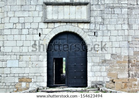 Big iron gates with opened door in the castle