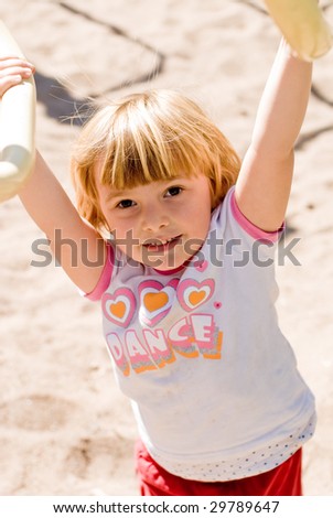A little girl playing outside, summer, playground.