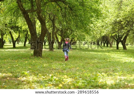 A silhouette of a girl running in a garden