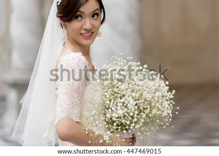 Young bride in wedding dress holding Gypsophila bouquet. Wedding flowers. Portrait bride