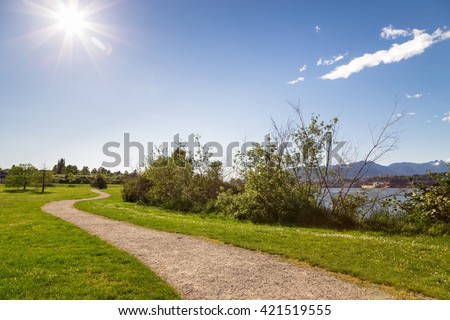 A walking path in a ocean-side city park on a sunny day.