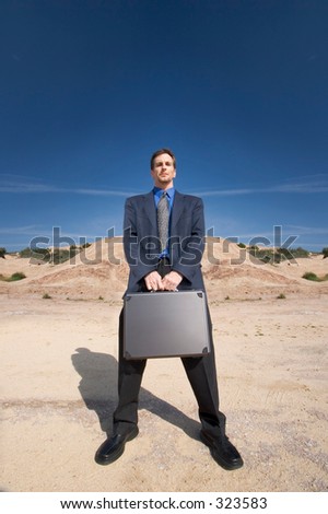 Man standing in the desert with his brief case