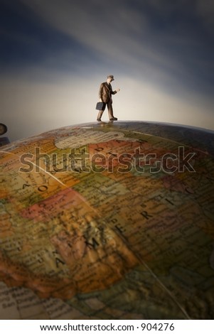 Business travel figure on globe with clouds in background and spotlight on figure