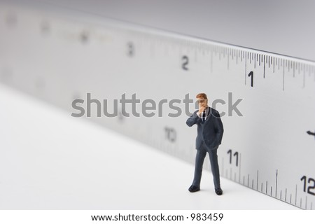 Measure of a man, business figure standing in front of a ruler