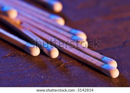 Macro photograph of matches with directional blue and orange lighting