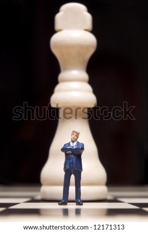 Business figurines placed on chessboard with chess pieces