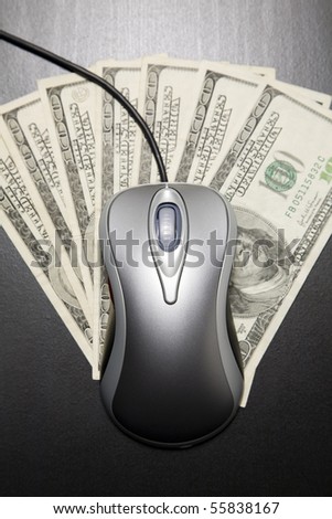 Metallic color computer mouse placed on $100 dollar bills