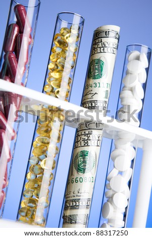 pills, vitamins and money in test tubes